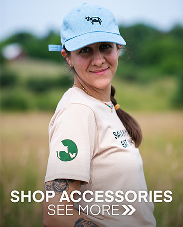 Woman wearing a denim cap with an embroidered cow and our new Save Animals Eat Plants t-shirt.  Click to shop our accessories.